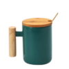 Green ceramic mug with bamboo lid and stirrer.