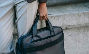 a-human-holding-a-black-laptop-bag