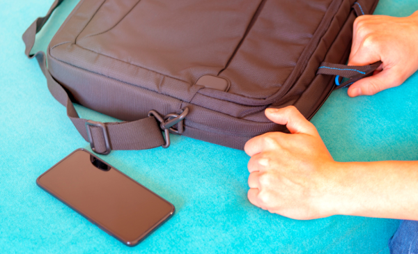 a-human-grabbing-a-brown-laptop-bag