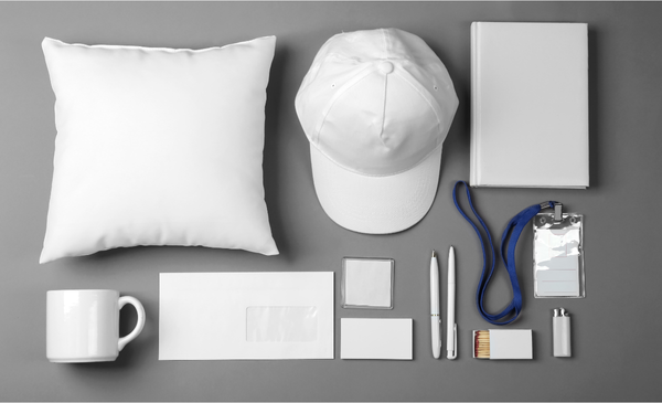 a-photo-of-white-pillow-white-cap-white-notebook-white-mug-white-envelope-white-papers-white-pen-and-ID-with-blue-lanyard